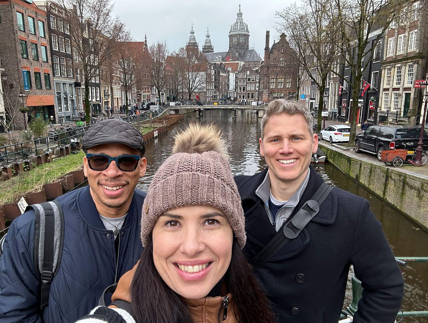 two men and a woman in the middle posing for a photo