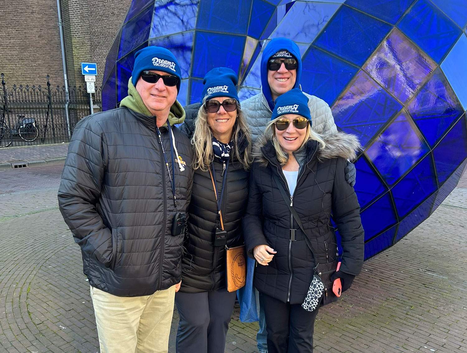 four people posing for a picture in winter hats and coats