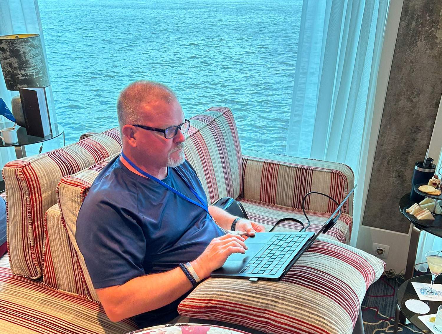 man on couch with laptop on a cruise ship
