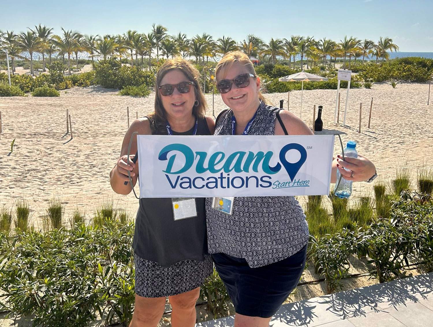 two women with a Dream Vacations sign